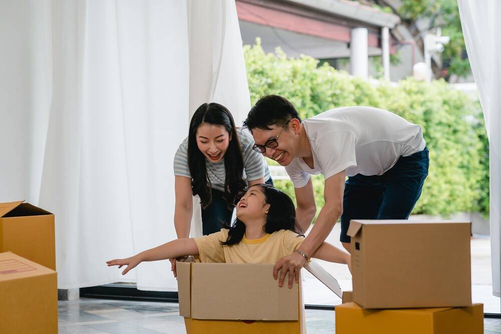 Happy Asian young family having fun laughing moving into new hom Happy Asian young family having fun laughing moving into new hom